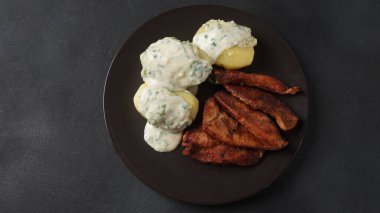 Kremalı maydanoz soslu kızarmış domuz eti ve masada haşlanmış patates ya da klasik Danimarka mutfağı Stegt matarası..