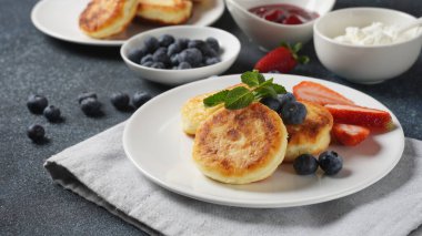 Süzme peynirli börek veya şurup veya taze yaban mersinli krep, çilek ve çilek reçeli. Lezzetli tatlı ya da tatlı kahvaltı. Rus, Ukrayna mutfağı