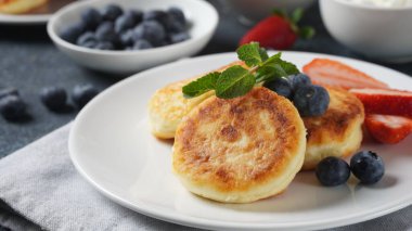Süzme peynirli börek veya şurup veya taze yaban mersinli krep, çilek ve çilek reçeli. Lezzetli tatlı ya da tatlı kahvaltı. Rus, Ukrayna mutfağı