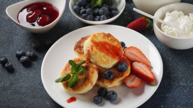 Süzme peynirli börek veya şurup veya taze yaban mersinli krep, çilek ve çilek reçeli. Lezzetli tatlı ya da tatlı kahvaltı. Rus, Ukrayna mutfağı