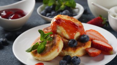 Süzme peynirli börek veya şurup veya taze yaban mersinli krep, çilek ve çilek reçeli. Lezzetli tatlı ya da tatlı kahvaltı. Rus, Ukrayna mutfağı