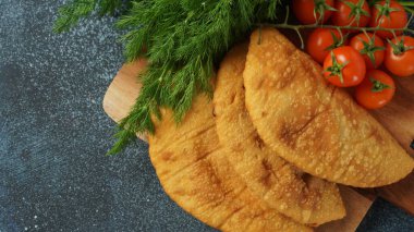 Et ve kiraz domatesli Cheburek. Geleneksel Romanya, Ukrayna, Rus ve Tatar yemekleri Ulusal Doğu Yemekleri. Etli turta, dana eti ya da kuzu eti