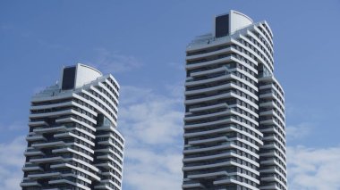 Gökyüzüne karşı gökdelenli bir apartman. Arka planda mavi gökyüzü olan modern, lüks bir apartman. İsrail