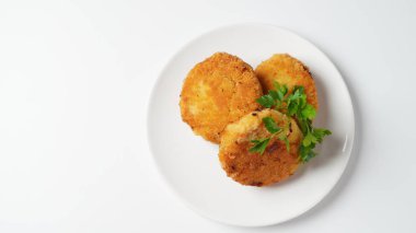 Tavuk pirzolası ile tabak. Maydanozla süslenmiş beyaz bir tabakta sulu pirzola.