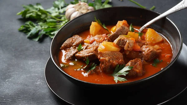 Beef goulash, soup and a stew, made of beef chuck steak, potatoes and plenty of paprika. Hungarian  traditional meal.