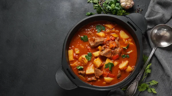 Beef goulash, soup and a stew, made of beef chuck steak, potatoes and plenty of paprika. Hungarian  traditional meal.