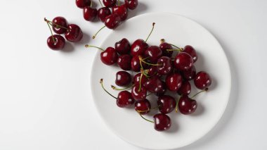 Bir tabakta tatlı kırmızı kirazlar, taze olgun kirazlar.