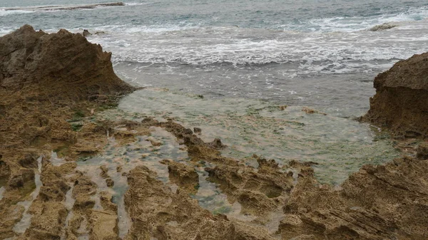 海滨的火山岩板充满了潮水 清澈海水边的火山岩 海岸天然岩石防波堤 — 图库照片