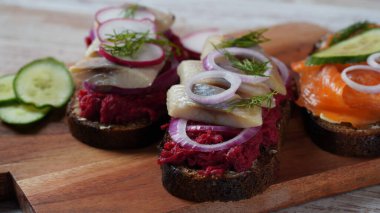 Koyu çavdar ekmeği, somon, pancar, kırmızı soğan ve turplu Danimarka sandviçi.