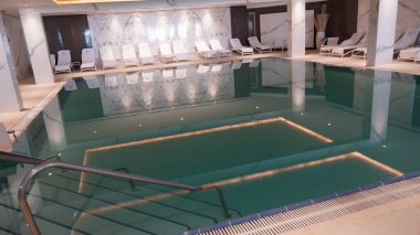 EIN BOKEK, İsrail - 6 Temmuz 2022: Ein Bokek Spa yüzme havuzu. Ölü Deniz tatil beldesi İsrail 'deki otelde maden suyu bulunan kapalı havuz..