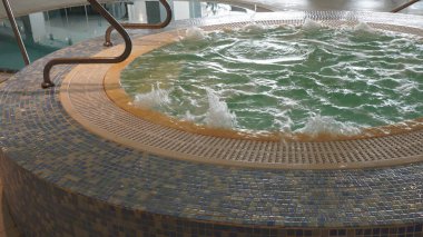 Empty jacuzzi in action. Spa jacuzzi with bubbling water in hotel