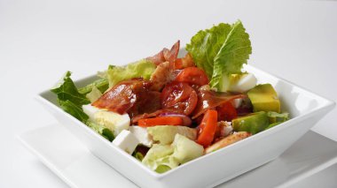 American cobb salad hard boiled eggs, cheese, avocado chunks, lettuce, grilled chicken breast, tomatoes and crispy fried bacon