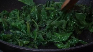 Kızartma tavasında ıspanak pişirmek. Taze ıspanak tavaya atılır.