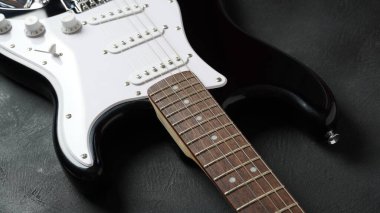 Front of electric guitar body on dark background.