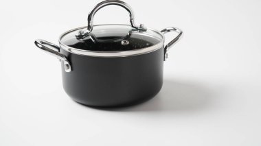 Beyaz arka planda siyah çömlek. Yemek pişirmek için araçlar