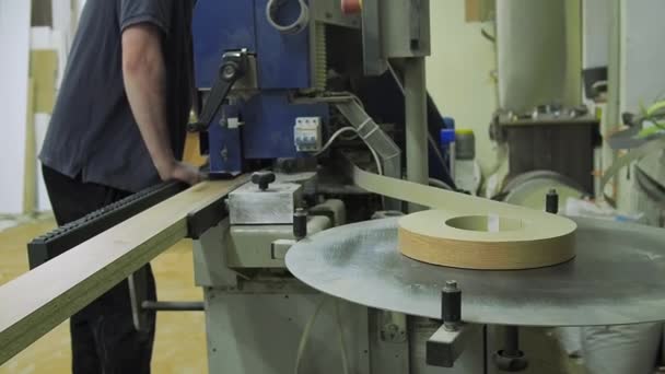 Lijmen proces materiaal voor boord spaanplaat randen. Kunststof voorgelijmde rand banding tape voor meubelproductie decor en reparatie. — Stockvideo