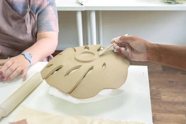 Kvinna hand keramik gör lera monstera löv i keramik verkstad studio. Process för att skapa keramiska vas. Handgjort, hobbykonst och hantverkskoncept — Stockfoto