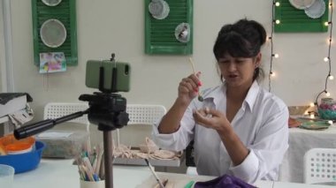 Seramik çevrimiçi kurs için resim stüdyosu video dersi veren kadın çömlek hocası ya da seramik ürünler üretmek için video ana sınıfını yönetiyor. vlog kaydedici kil modelleme ile video.