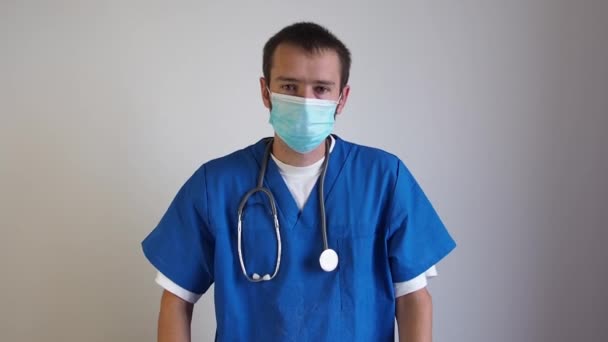 Σοβαρή κουρασμένος γιατρός άνθρωπος κοιτάζοντας κάμερα και απογειώνεται μάσκα ιατρική και stetoskop και να κάνει μακριά — Αρχείο Βίντεο