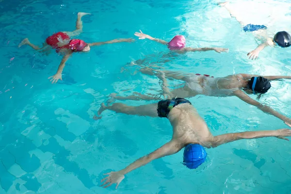 Grupo de crianças no treinamento de piscina jazia na wather em estilo estrela. — Fotografia de Stock