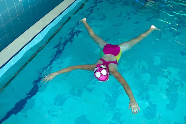 Niña en el entrenamiento de la piscina yacía en wather en estilo estrella. banner con espacio de copia. —  Fotos de Stock