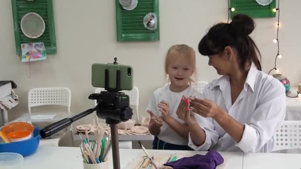 Mujer tutor de cerámica en el estudio de arte con la grabación doughter video lección para el curso en línea de cerámica o dirige una clase magistral sobre la creación de productos de cerámica. Influencer creando contenido interesante — Vídeos de Stock