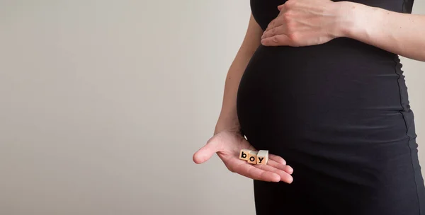Беременная женщина с мужским словом из блоков. Родитель в ожидании мальчика. Баннер с копировальным пространством — стоковое фото