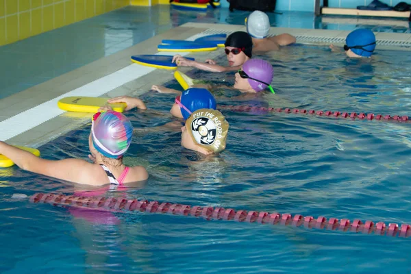 Mińsk, BELARUS - 30 października 2021: Grupa dzieci w basenie ma szkolenie pływackie z trenerem — Zdjęcie stockowe