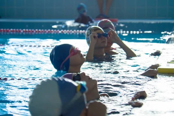 Minsk, BELARUS - 30. Oktober 2021: Kindergruppe im Schwimmbad hat Schwimmtraining mit Trainer — Stockfoto