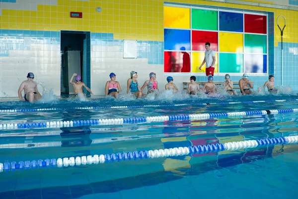 Mińsk, BELARUS - 30 października 2021: Lekcja grupowa z trenerem w basenie. Trener przydziela zadania i kontroluje technikę ukończenia. — Zdjęcie stockowe