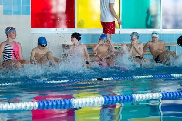 Minsk, BELARUS - 30 octobre 2021 : Groupe d'enfants dans la piscine ont une formation de natation avec entraîneur — Photo