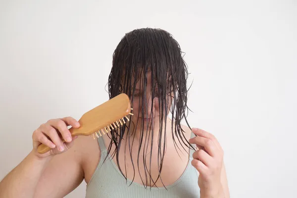 Vrouw borstelen met kammen verwarde haar met conditioner na douche slow motion. — Stockfoto