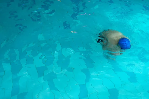 Entraînement d'enfant dans une piscine. exercice de flottaison pour la flottabilité et une bonne respiration. délivrance d'une personne de la peur de l'eau avec espace de copie pour le texte. — Photo