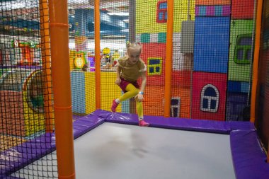 Küçük çocuk, trambolin içinde kapalı Bahçesi atlama. Etkin toddler kız spor merkezinde eğleniyor
