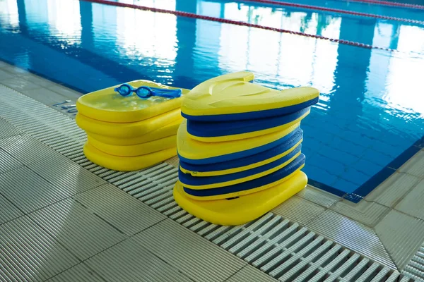 Stapel van de kleurrijke zwemplanken op naast het zwembad in sportcentrum — Stockfoto