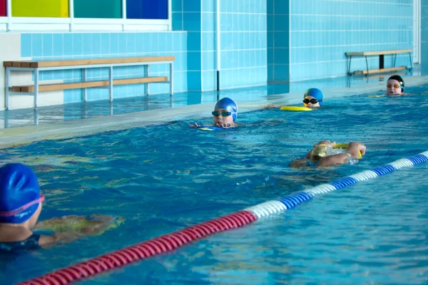 Minsk, BELARUS - 30 octobre 2021 : Groupe d'enfants dans la piscine ont une formation de natation avec entraîneur — Photo