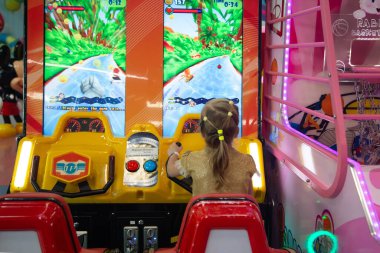 Minsk, BELARUS - 14 Eylül 2021: Küçük kız çocuk alışveriş merkezinde konsol oyunu oynuyor