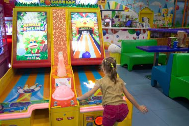 Minsk, BELARUS - 14 Eylül 2021: Küçük kız çocuk alışveriş merkezinde topla konsol oyunu oynuyor