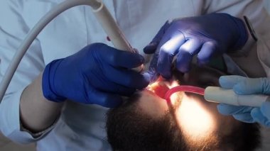 Diş hekimi ultrasonlu hastaya ağız temizliği yapar. Diş kliniğinde plaket ve tartar temizliği..