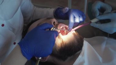 Diş hekimi ultrasonlu hastaya ağız temizliği yapar. Diş kliniğinde plaket ve tartar temizliği..