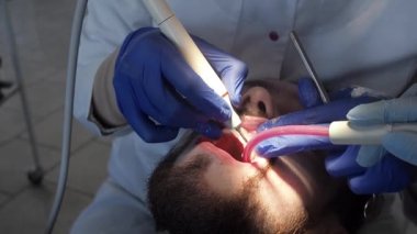 Diş hekimi ultrasonlu hastaya ağız temizliği yapar. Diş kliniğinde plaket ve tartar temizliği..
