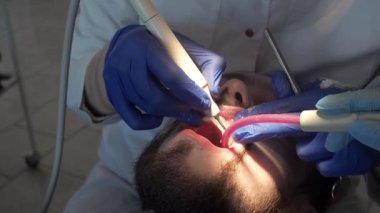 Diş hekimi ultrasonlu hastaya ağız temizliği yapar. Diş kliniğinde plaket ve tartar temizliği..