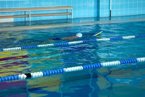 Irriconoscibile bambino nuoto stile freestyle formazione in piscina nuotatore con spruzzi d'acqua. — Foto Stock