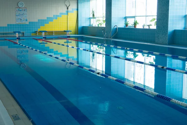 Sisätilojen julkinen uima-allas. tyhjä uima-allas ennen uimatunteja. tekijänoikeusvapaita kuvapankkikuvia