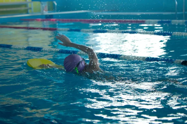 Entraînement de style nage libre pour enfants méconnaissable dans une piscine avec éclaboussures d'eau. — Photo
