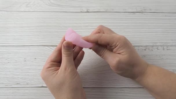 Kvinnlig hand håller menstruation kopp och visar C vika metoder — Stockvideo