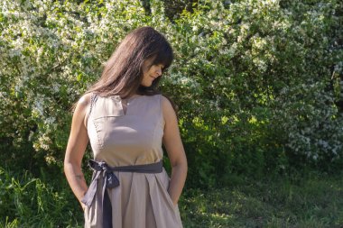 Baharda güneşli bir havada çiçek bahçesinde rüya gibi bir kadın.