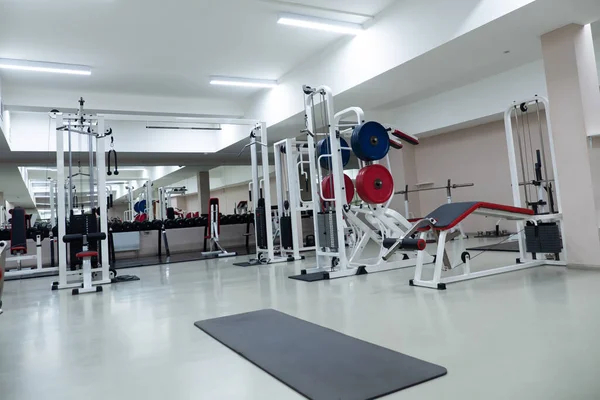 Ginásio moderna sala de fitness center. corredor vazio com simuladores em diferentes músculos. — Fotografia de Stock