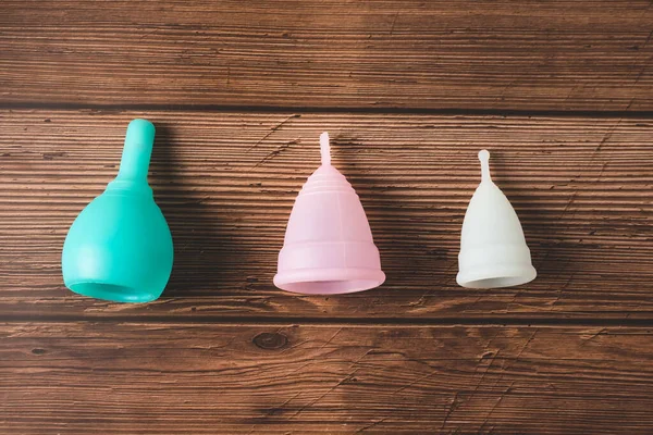 Менструальные силиконовые чашки различных цветов, форм и возможностей для менструации цикла. Устойчивые и комфортные периоды менструации. Многоразовые экологически чистые и нулевые продукты гигиены отходов Лицензионные Стоковые Фото