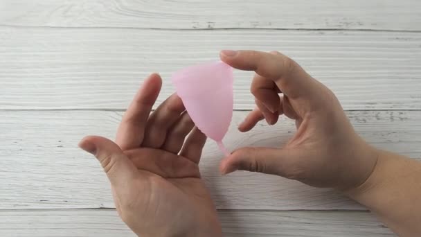 Vrouw hand houden menstruele beker en demonstreren driehoek vouwen methoden — Stockvideo